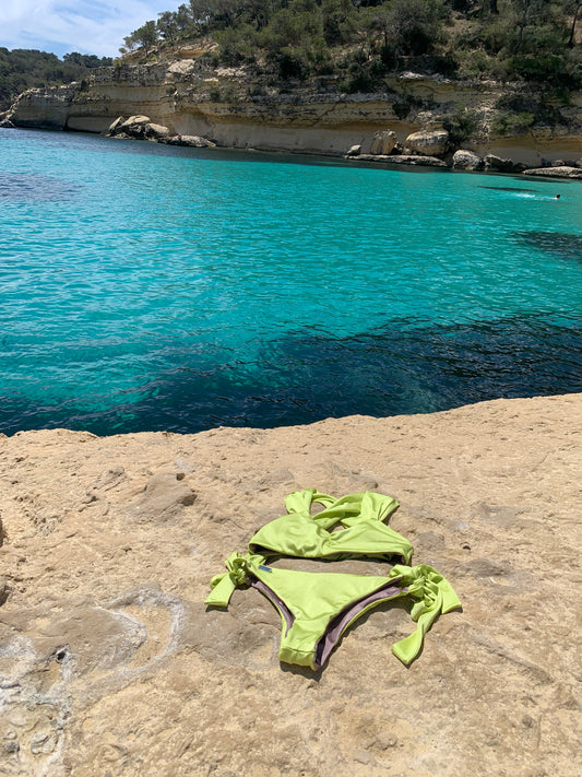 Bikini tendencia 2023 verano. bikini verde en cala agua turquesa